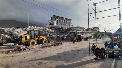 Heavy equipment clearing rubble from building collapse site in La Guaira Stock Footage 340916428