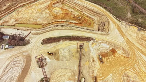 Heavy equipment operates in a large mining site with dirt roads and machinery Stock Footage 331901470