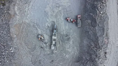 Heavy equipment operates in a mining site as workers manage the extraction Stock Footage 340175462