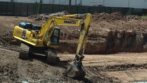 A heavy equipment operator maneuvers an excavator while working on a project in Stock Footage 341042227