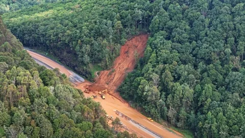 Heavy Equipment works to clear Interstate 40 after Hurricane Helene mudslide. Stock Footage 299827971