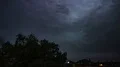 Heavy evening thunderstorm clouds over backstreet city roofs while TV is running 4k or 4k+ Resolution