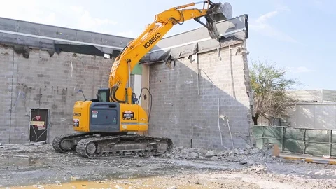 Heavy excavator construction machine destroys wall at demolition site A Stock Footage 125056700