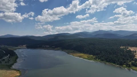 Heavy fluffy clouds passing over a lake Stock-Footage 340471094