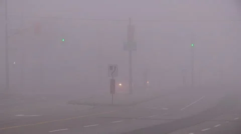Heavy fog reducing visibility for drivers at city intersection Stock Footage 57951387