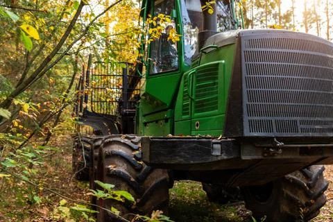 Heavy forestry machine with muddy tires, crane, grapple, and metal frame stan Stock Photos