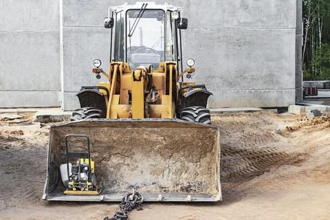 Heavy front loader on a construction site with a construction tool Photos