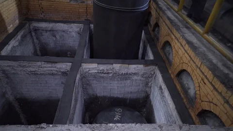 Heavy graphite rod is lowered into one of the cells of the refrigerating chamber Stock Footage 115927677