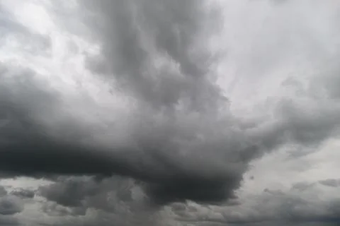 Heavy gray clouds blanket the sky, swirling in intricate patterns, creating a Stock Photos