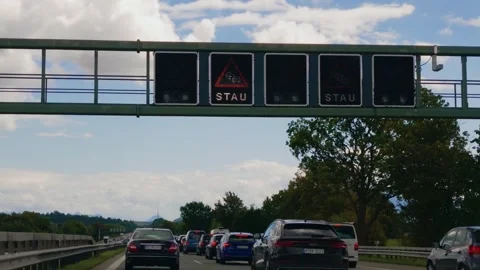 Heavy highway traffic jam and electronic warning signs on German Autobahn A8 in Video stock 346495918