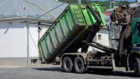 Heavy Hooklift Truck Loading Green Waste Container for Recycling and Disposal Stock Footage 346406373