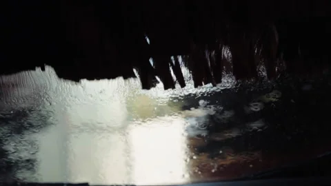 Heavy horizontal and vertical brushes rotating and cleaning car windshield with Stock-Footage 130348223