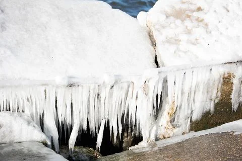 Heavy ice hanging from a broken dock on the water Stock Photos