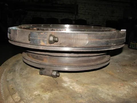 Heavy, industrial component, possibly part of machinery, rests on a texture.. Stock Photos