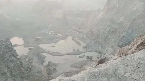 Heavy industrial mining operation inside a deep canyon quarry with excavator Stock Footage 337908058