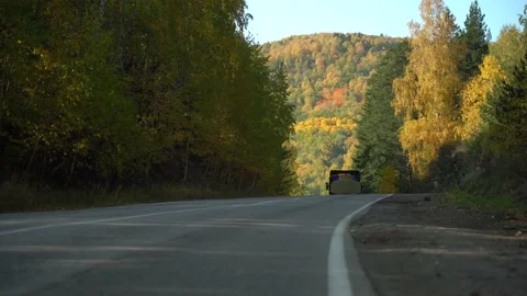 Heavy Laden Dump Trucks Drive in a Mountainous Wooded area on an asphalt Road on Stock Footage 152679770