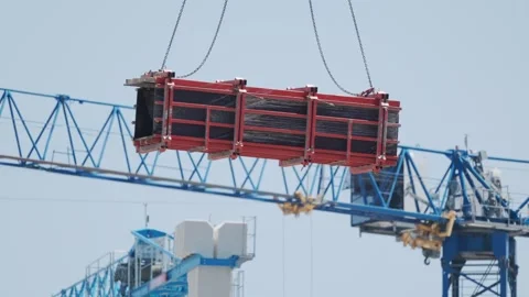 Heavy load being lifted by crane at construction site in bright day Stock Footage 338245936