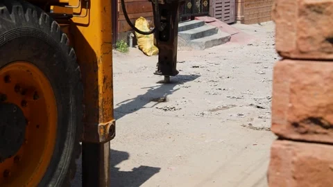 Heavy machine breaking pavement for daytime construction Stock Footage 313471121
