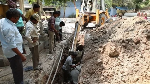 Heavy machine digging for replacing sewage pipelines Stock Footage 75306690