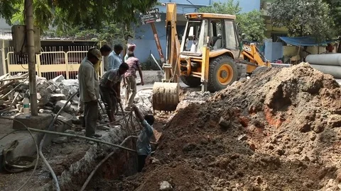Heavy machine digging trench to replace sewage pipelines Stock Footage 75306738