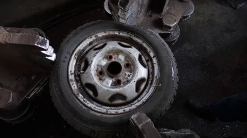 Heavy machine squeezes a car wheel Stock Footage