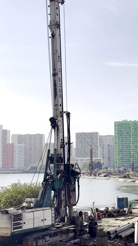Heavy machinery in action, showcasing a drilling rig and excavator working Stock Footage 316474193
