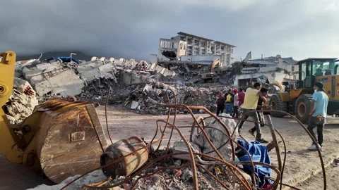 Heavy machinery and rescue workers clearing tons of concrete debris and rebar Stock Footage 342664193