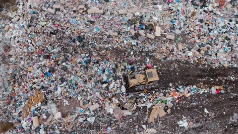 Heavy machinery clearing debris at a large landfill site in the afternoon Видео 292058828