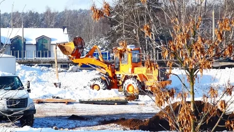 Heavy machinery clears snow at construction site in winter morning Stock Footage 328245561