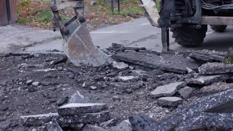Heavy Machinery is Lifting Asphalt at a Construction Site in Urban Development Stock Footage 308333550