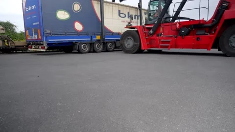 Heavy Machinery Low Angle View of Red Reach Stacker Lifting Cargo Trailer Stock Footage 338372096