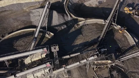Heavy machinery operates in a busy mining site during daylight hours Stock Footage 329998396