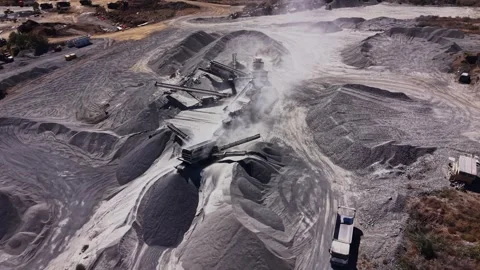 Heavy machinery operates at a construction site with piles of gravel Stock Footage 344539011