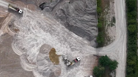 Heavy machinery operates at a quarry, loading gravel into construction trucks Stock Footage 342703896
