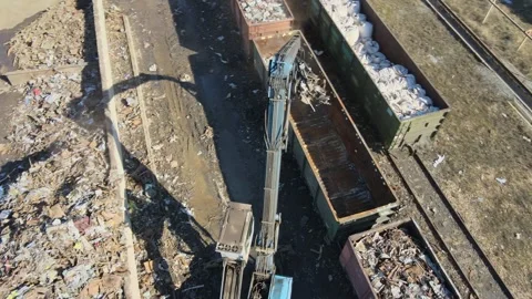 Heavy machinery operates at a scrap yard in a large urban area Stock Footage 306300419