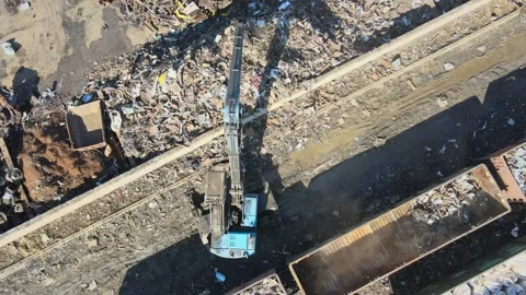 Heavy machinery operates at a scrap yard in a large urban area Stock Footage 306300477