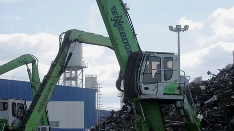 Heavy machinery operates surrounded by the bulks of scrap metal Stock Footage 71590801
