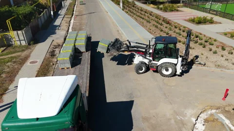 Heavy machinery operator skillfully maneuvers a compact loader to lift and Stock Footage 318712165