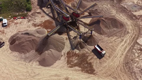 Heavy machinery processes sand and gravel at a construction site during daytime Stock Footage 340173935