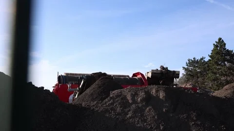 Heavy machinery processes soil and mixed ground waste as rotating equipment Stock Footage 321650846
