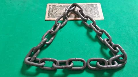 Heavy metal chains arranged in triangle shape over dollar bill Stock Photos