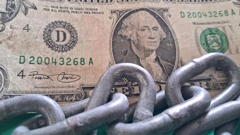 Heavy metal chains resting on a single United States dollar bill Stock Photos