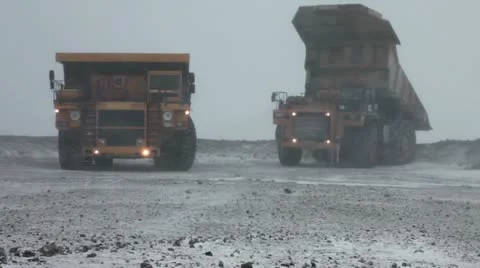 Heavy mining dump trucks unload ore Stock Footage 10804838