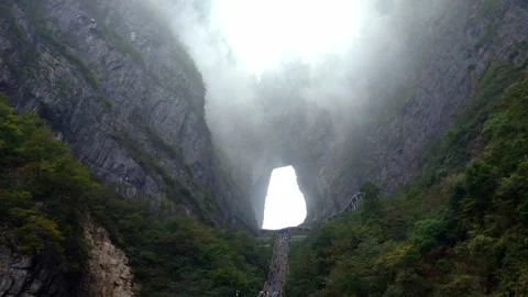 Heavy Mist Passing Through Tianmen Cave Heaven's Gate at Tianmen Mountain in Stock Footage 336742681