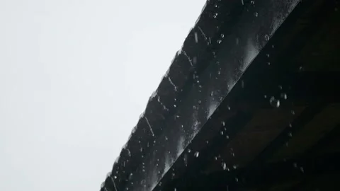 Heavy monsoon rain running off a tiled roof slow motion Stock Footage 137556613