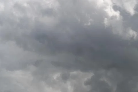 Heavy overcast clouds sweeping across frame, layered gray masses creating bro 写真素材
