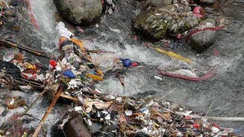 Heavy plastic pollution destroying a natural river in slow motion. Stock Footage 336322773