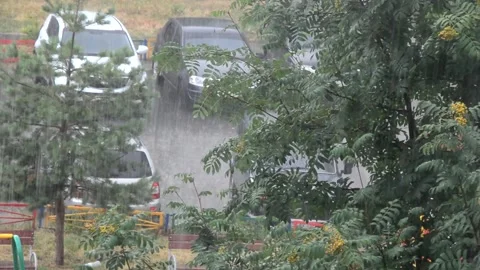 Heavy rain against the tree and a children's playground streams of water Vidéo 143337841