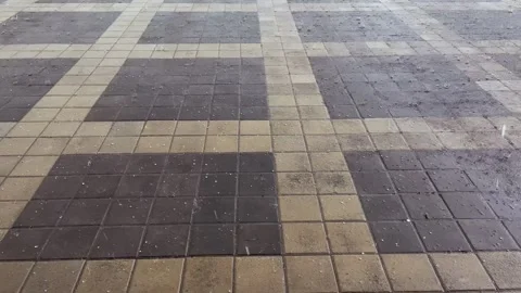 Heavy rain and hail fall on the paving slabs. Drops break on the surface. Video Stockbeeldmateriaal 334490111