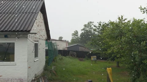 Heavy rain and hail falling in rural backyard garden Stock Footage 338410084